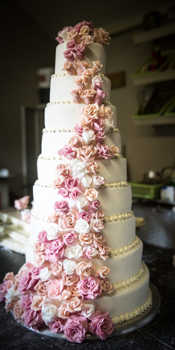 Meerlagige huwelijkstaart van Bakkerij Van Roey met room en verse decoratie
